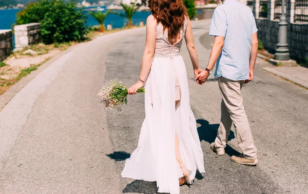 Newlyweds hold hands on the sea. Couple holding hands. Wedding i — Stock Photo, Image