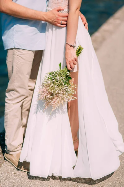 O noivo abraça a noiva na praia. Casamento em Montenegro — Fotografia de Stock