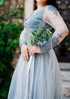 Beyaz-mavi dre gelinin elinde lavanta düğün buketi