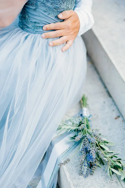 Lavendel Hochzeitsstrauß liegt auf der Treppe neben der Braut ein — Stockfoto