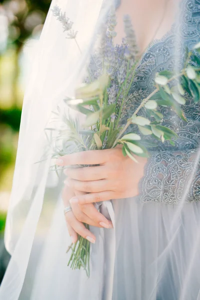 Lavendel bruiloft boeket in handen van de bruid onder sluier in de pal- — Stockfoto