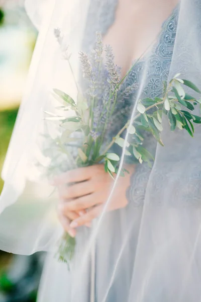 Lavendel Hochzeitsstrauß in den Händen der Braut unter Schleier in pal — Stockfoto