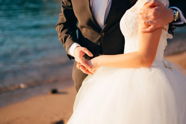 The groom embraces the bride on the beach. Wedding in Montenegro — Stock Photo, Image
