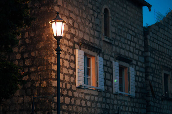 Vintage lamp on the wall on the street.