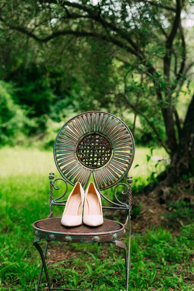 Взуття наречених на металевому стільці вінтажне в оливковому лісі — стокове фото