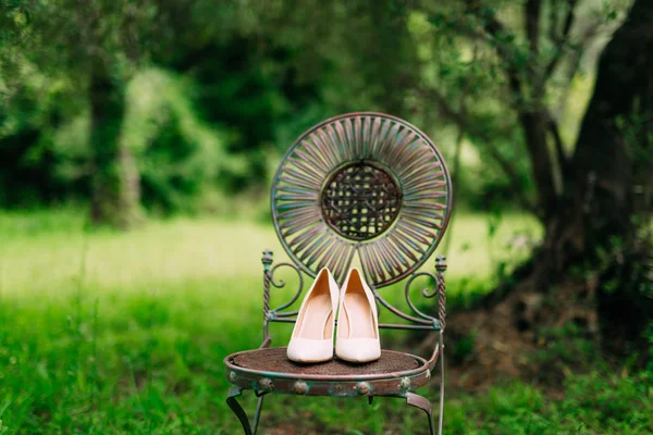 Bruiden schoenen op een vintage metalen stoel in olijf bos — Stockfoto