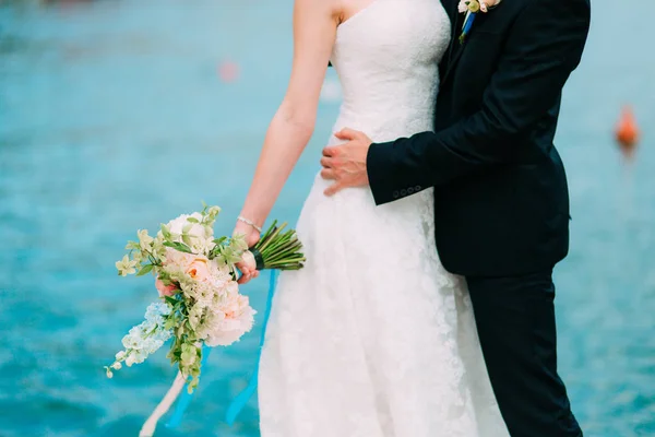 Pengantin pria memeluk pengantin wanita di pantai. Pernikahan di Montenegro — Stok Foto