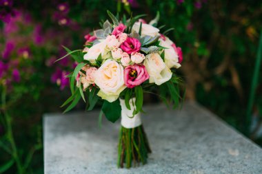 Begonvil taş pilla üzerinde bir arka plan üzerinde gül buketi