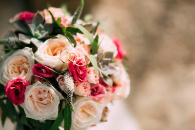 Alyans ve demet güller, peonies ve succulents üzerinde