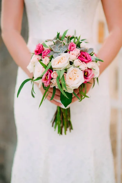 Весільний букет з троянд, півоній і сукулентів в руках — стокове фото