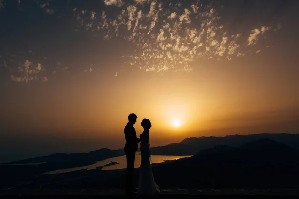 Silhueta dos recém-casados contra o céu ao pôr-do-sol. Casamento i — Fotografia de Stock