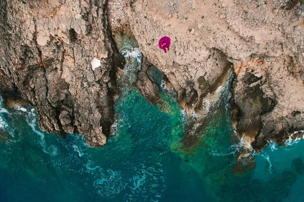 Uma menina em um vestido roxo descansa em uma praia rochosa em Montenegro, um — Fotografia de Stock