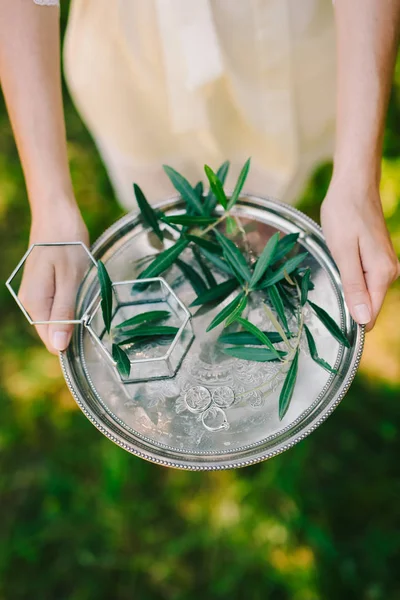 stock image Wedding rings on a silver tray with olive branches in their hand