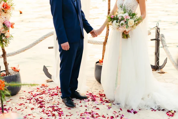 Nygifta håller händerna vid vigseln. Par innehav — Stockfoto
