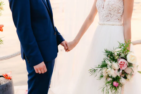 Os recém-casados dão as mãos na cerimônia de casamento. Casal exploração — Fotografia de Stock