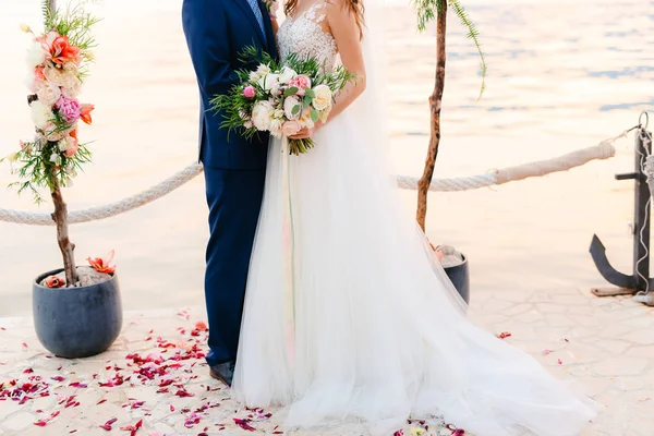 Lo sposo abbraccia la sposa sulla spiaggia. Matrimonio in Montenegro — Foto Stock