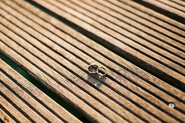 Wedding rings on a light wooden texture