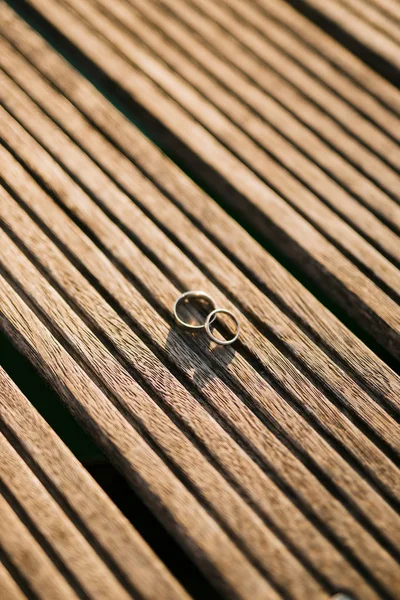 Wedding rings on a light wooden texture