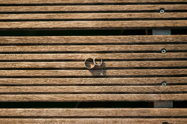 Snubní prsteny na lehké dřevěné textury — Stock fotografie