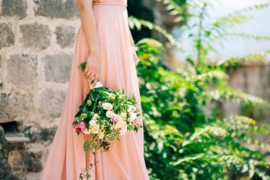 Düğün gül ve peonies gelinin elinde. İçinde düğün