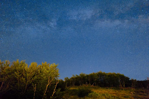 O céu estrelado e a Via Láctea sobre as montanhas e a frente — Fotografia de Stock