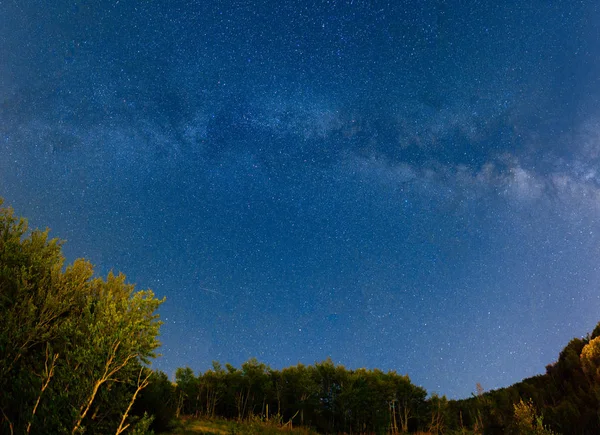 Le ciel étoilé et la Voie lactée sur les montagnes et le devant — Photo