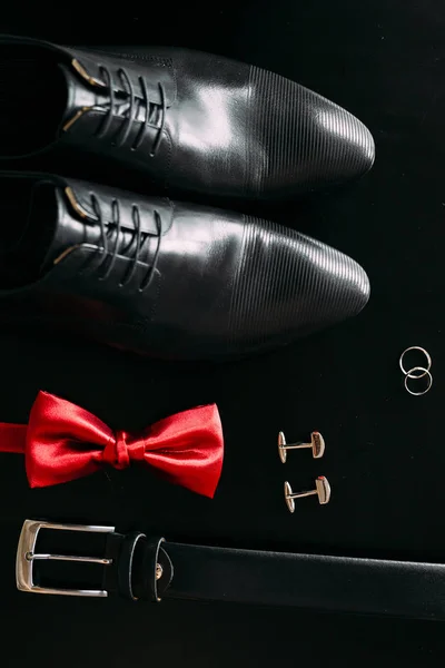 Zapatos de hombre negros, gemelos, anillos de boda, un cinturón negro y un —  Fotos de Stock
