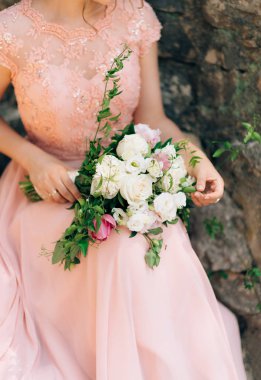 Düğün gül ve peonies gelinin elinde. İçinde düğün