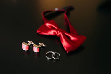 Damat, kırmızı kravat, kol düğmesi, kemerinde bir bla siyah ayakkabı