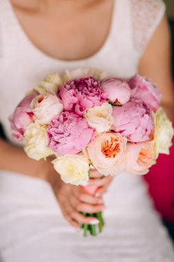 Düğün gül ve peonies gelinin elinde. İçinde düğün