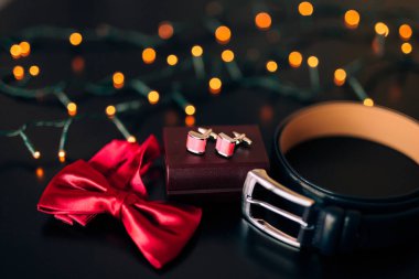 Damat, kırmızı kravat, kol düğmesi, kemerinde bir bla siyah ayakkabı