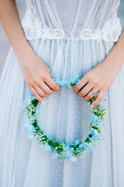 Wreath on a head of blue and white flowers in the brides hand i — Stock Photo, Image