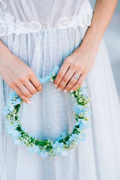 Ghirlanda su una testa di fiori blu e bianchi nella mano spose i — Foto Stock