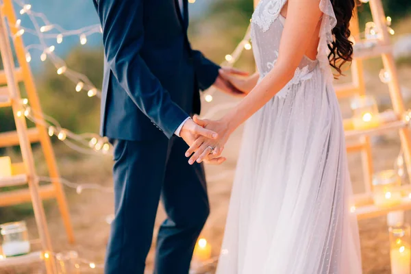 Yeni evliler düğün töreninde elele tutuşun. Çift holding — Stok fotoğraf