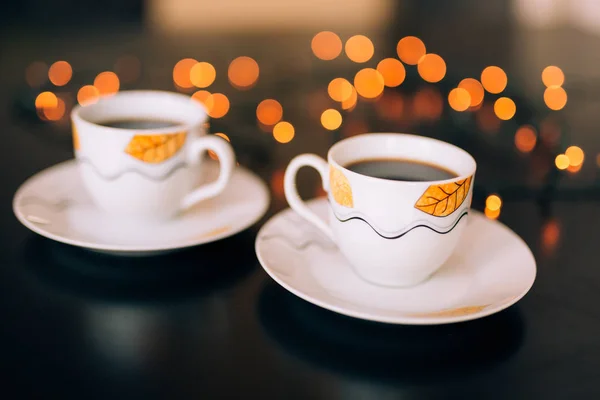 Dos tazas de café en la mesa en el fondo bokeh . — Foto de Stock