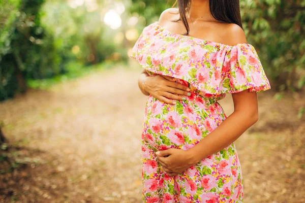 Беременная женщина держит живот руками — стоковое фото