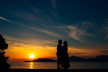 Sahilde gün batımında siluetleri