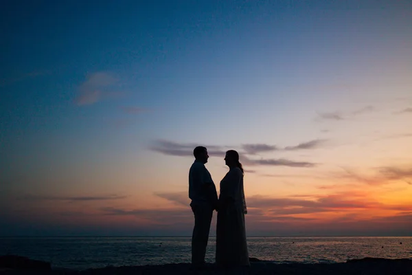 Silhouette al tramonto sulla spiaggia — Foto Stock