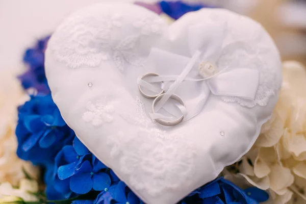 Anillos de boda de una pareja recién casada en un cojín para anillos . —  Fotos de Stock