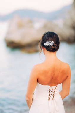 Bir yat deniz kıyısında bir kız bakar.