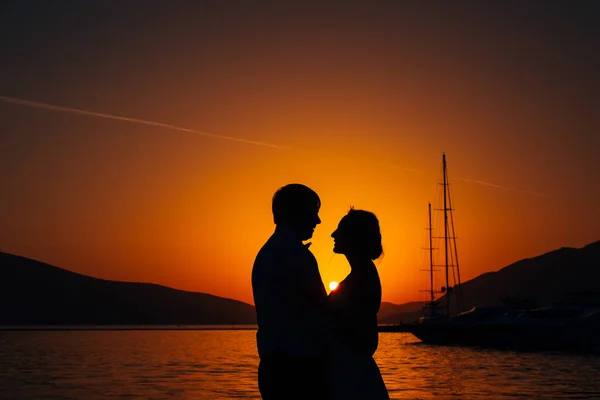 Silueta de una pareja recién casada en el fondo del sol poniente — Foto de Stock