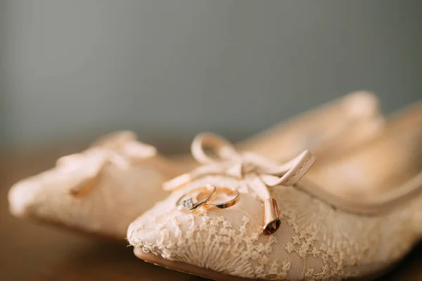 Los zapatos de crema de la novia sobre verde sobre la mesa de madera —  Fotos de Stock