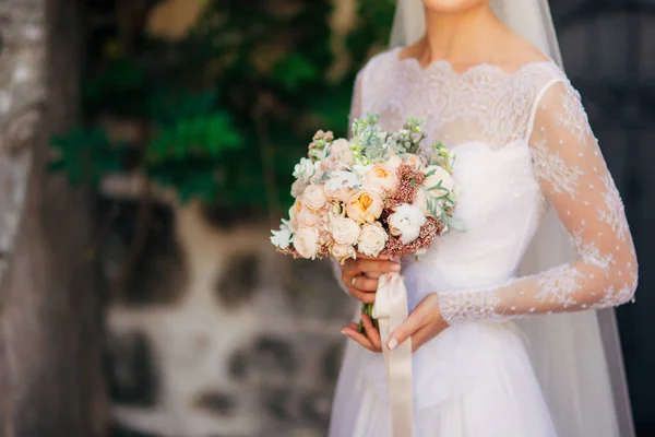 Bröllop bukett i händerna på bruden — Stockfoto
