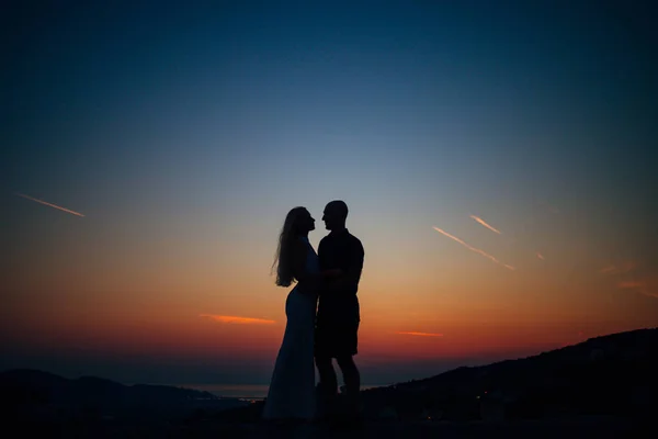 Silhouette of a newlywed couple on the background of the setting sun — Stock Photo, Image