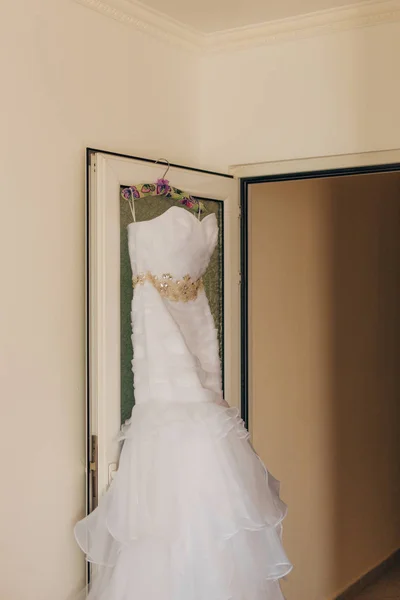 The bride's dress on a hanger in the room