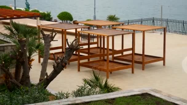 Wooden chaise lounges by the sea. Hotel in Kotor Bay in Monteneg — Stock Video