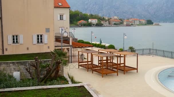 Chaises longues en bois au bord de la mer. Hôtel dans la baie de Kotor — Video