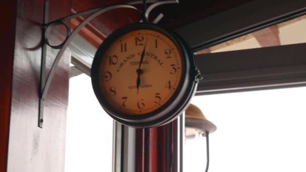 Vintage wall clock on a metal forged bracket on wall. — Stock Video