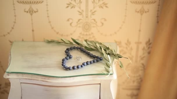 一颗心的蓝莓，br 旁边的桌子上的结婚戒指 — 图库视频影像