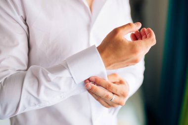 Kelepçeleri kadar düğmelerini. Damat kol düğmeleri giyer. İşadamı ekler